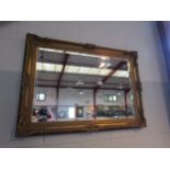 A bevel edged wall mirror with ornate gilt frame, 65cm x 91cm including frame
