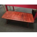 A 1960s Ercol elm coffee table, slatted undertier, heavily varnished to top, 35cm high x 105cm
