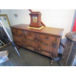 An Old Charm style sideboard with linen fold decoration, three drawers over three doors on stretcher