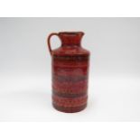 An Italian Bitossi jug in rust red glaze and impressed motif detail, 26cm high