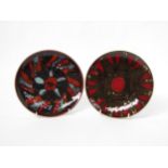 Two Poole Delphis 20.5cm diameter plates, black, reds and orange glazed. Black back stamps. (Heat