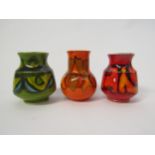 Three Poole Delphis small vases in green, red and orange. Various painters marks. Tallest 10cm