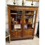 A late 19th Century inlaid rosewood two-door glazed display cabinet with brass edging to the door,