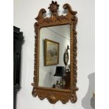 A late 19th Century carved wood and gilded mirror with broken arch pediment, acanthus scroll