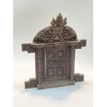 A carved wood decorative table top doorway from Kathmandu, Nepal, 46cm tall