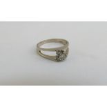 A white gold ring set with a single diamond in an open split shank, 0.20ct approx, stamped 18ct.