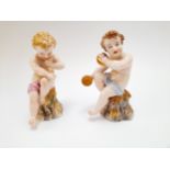 A Royal Worcester figure of a putto playing a horn. Hand a/f. A matching cymbal-playing putto,