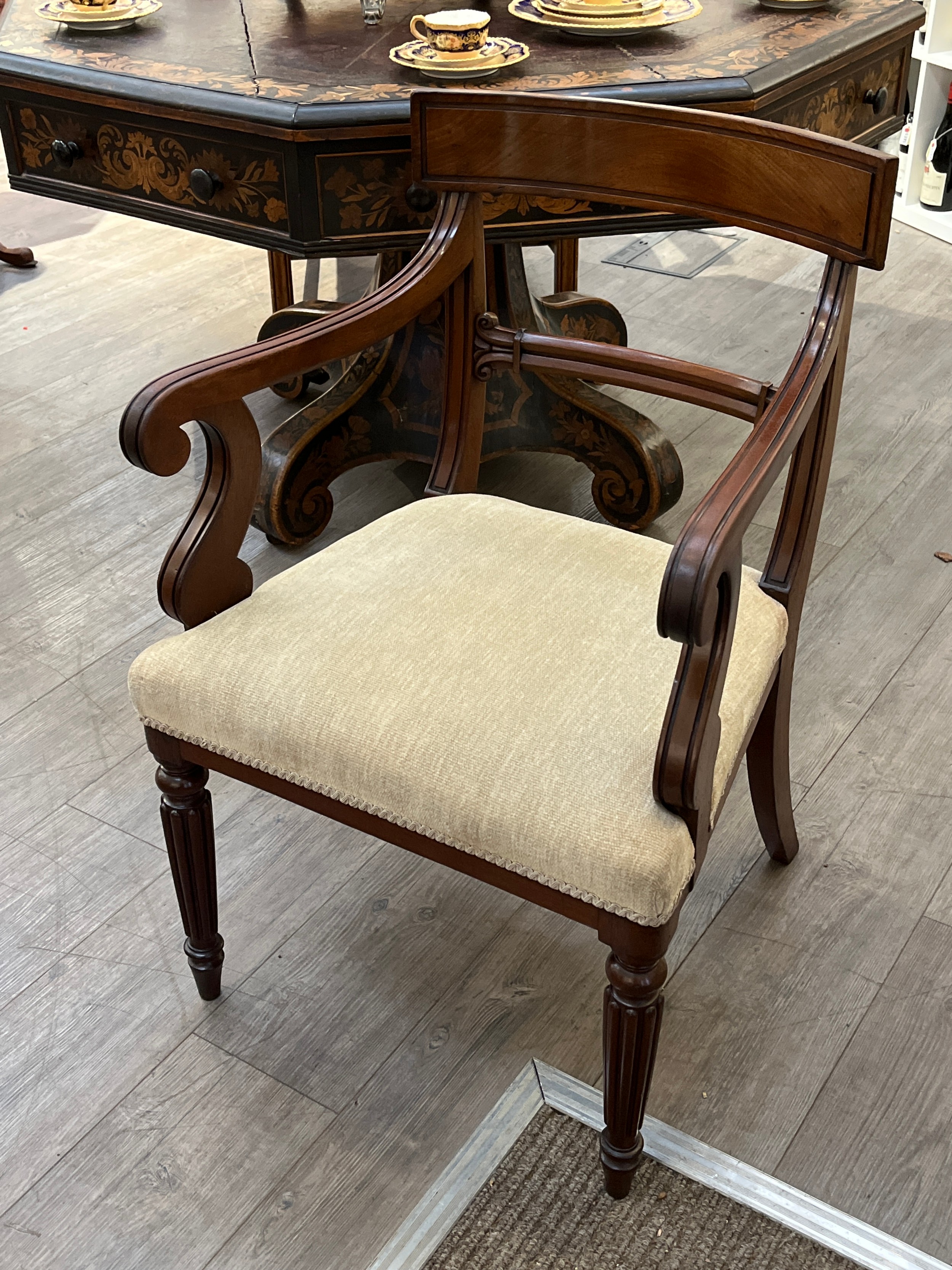 A Georgian mahogany scroll arm chair with carved bar back rest on turned and tapering reeded fore