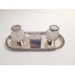 An Edwardian silver two bottle inkstand of rounded rectangular form with central stamp box,