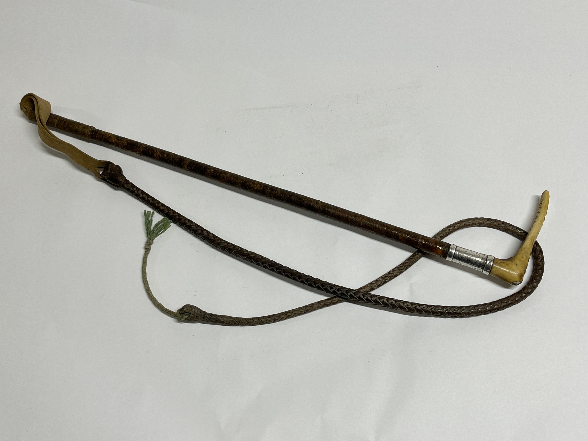 A vintage carriage whip, leather shaft with silver collar and horn top, knotted leather thong