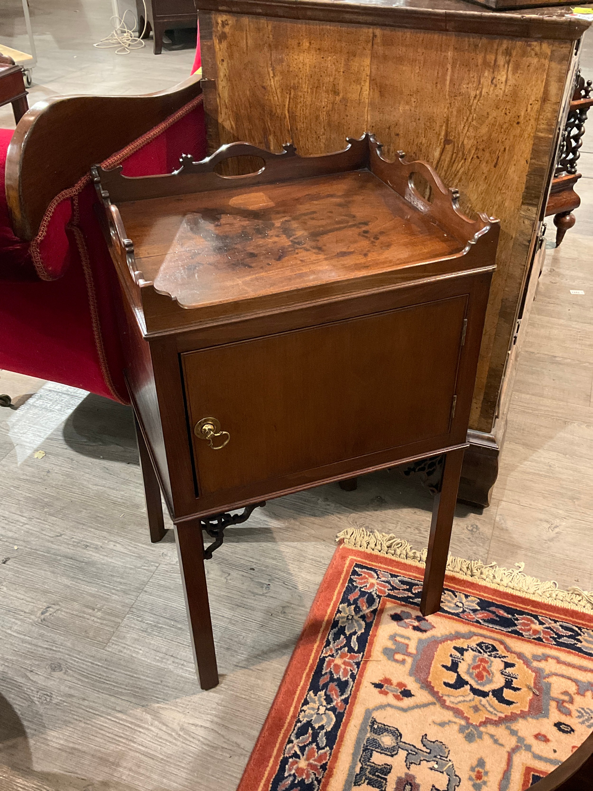 A George III mahogany nightstand the fretwork raised gallery over a single door cupboard on internal