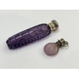 An amethyst glass scent bottle with rectangular cut panelled sides, white metal embossed lid,
