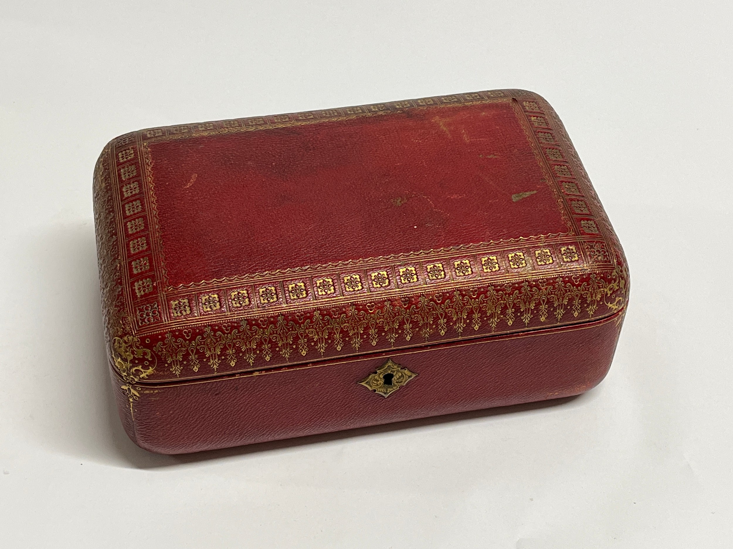 A 19th Century red leather casket with gilt tooled decoration to the exterior. With key. 27cm x 17cm