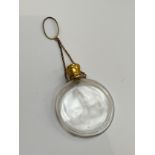 A plain glass scent bottle of moon flask style form, with unmarked gold hinged lid, glass stopper,