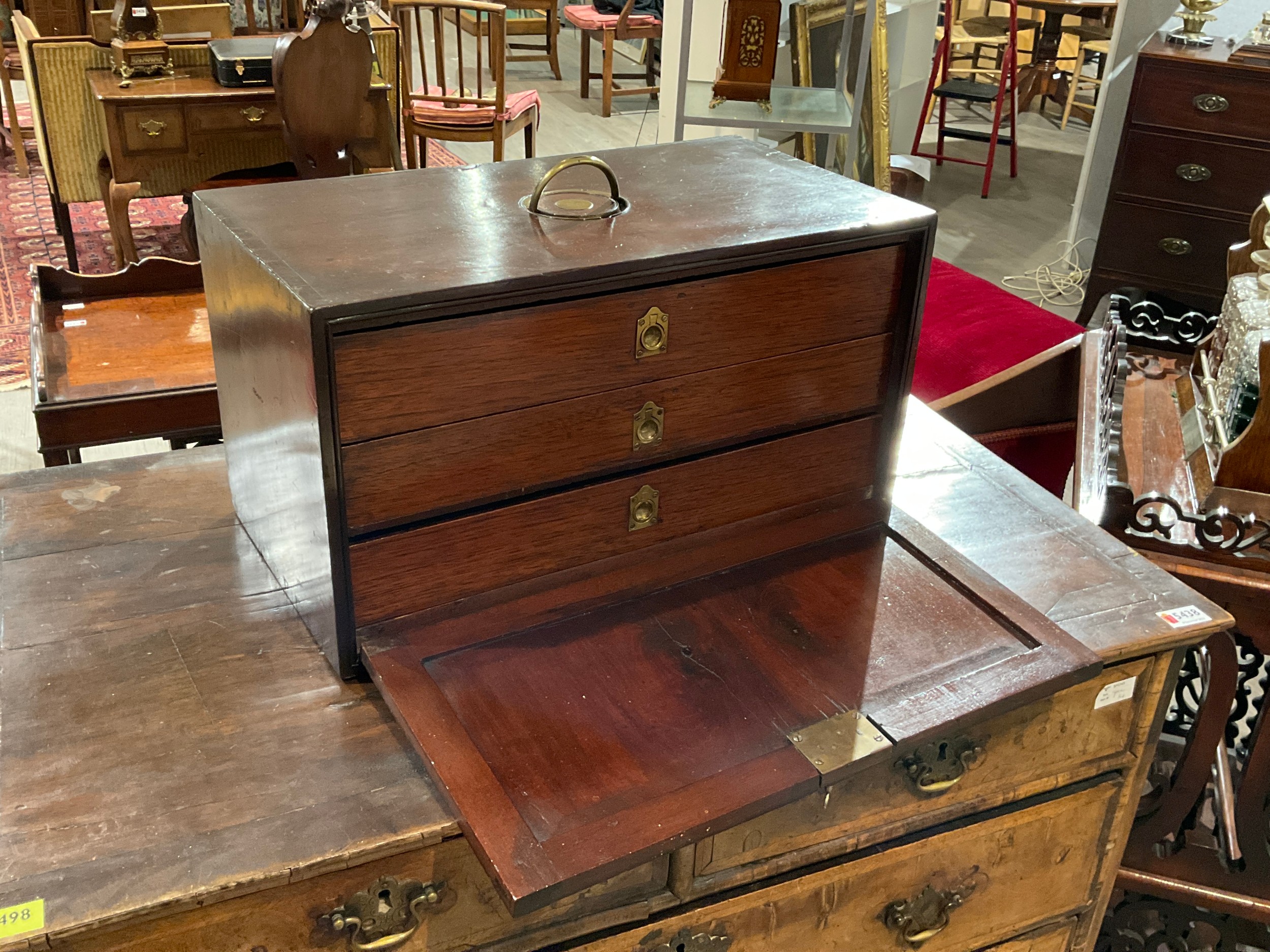 A George III mahogany three drawer cabinet with exposed dove tails the unusual brass semi circular