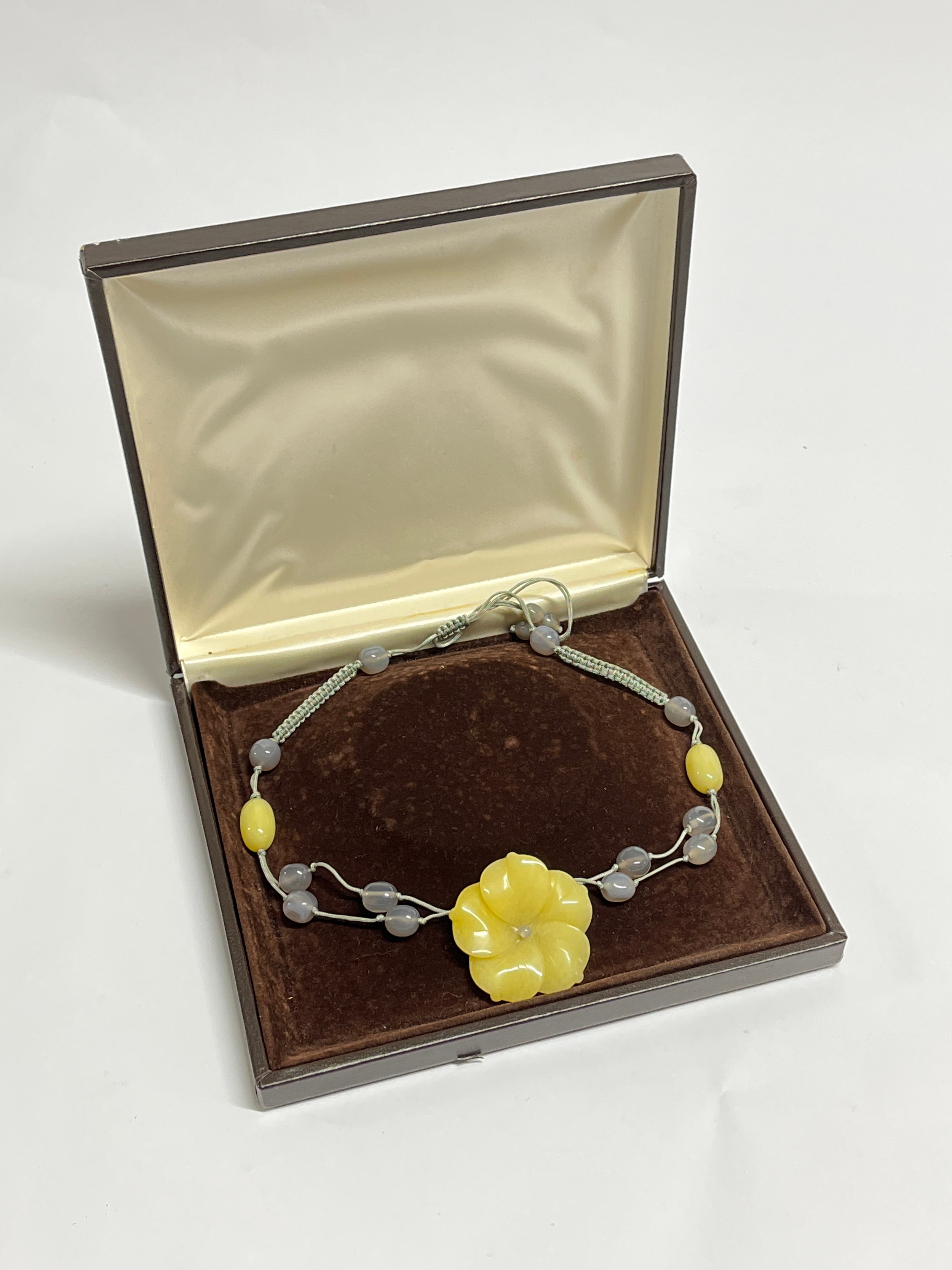 A jadeite necklace with large yellow jadeite carved lotus flower centre