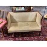 Circa 1890 a mahogany and satin walnut crossbanded two seater sofa on turned and reeded tapering