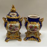 A pair of Rockingham porcelain lidded urns, blue ground with floral panels, enriched with gilt,
