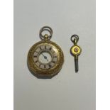 A gold half hunter fob watch with engraved outer case having a pale pink enamel outer with Roman