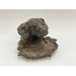 A Victorian cast iron dog head shaped inkwell with glass inset eyes and lead liner