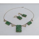 A pair of carved jade drop earrings with a similar necklace with three carved jade panels, (chain