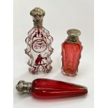 Three various scent bottles, one enriched with gilt, one ruby glass and of tapering form, one with