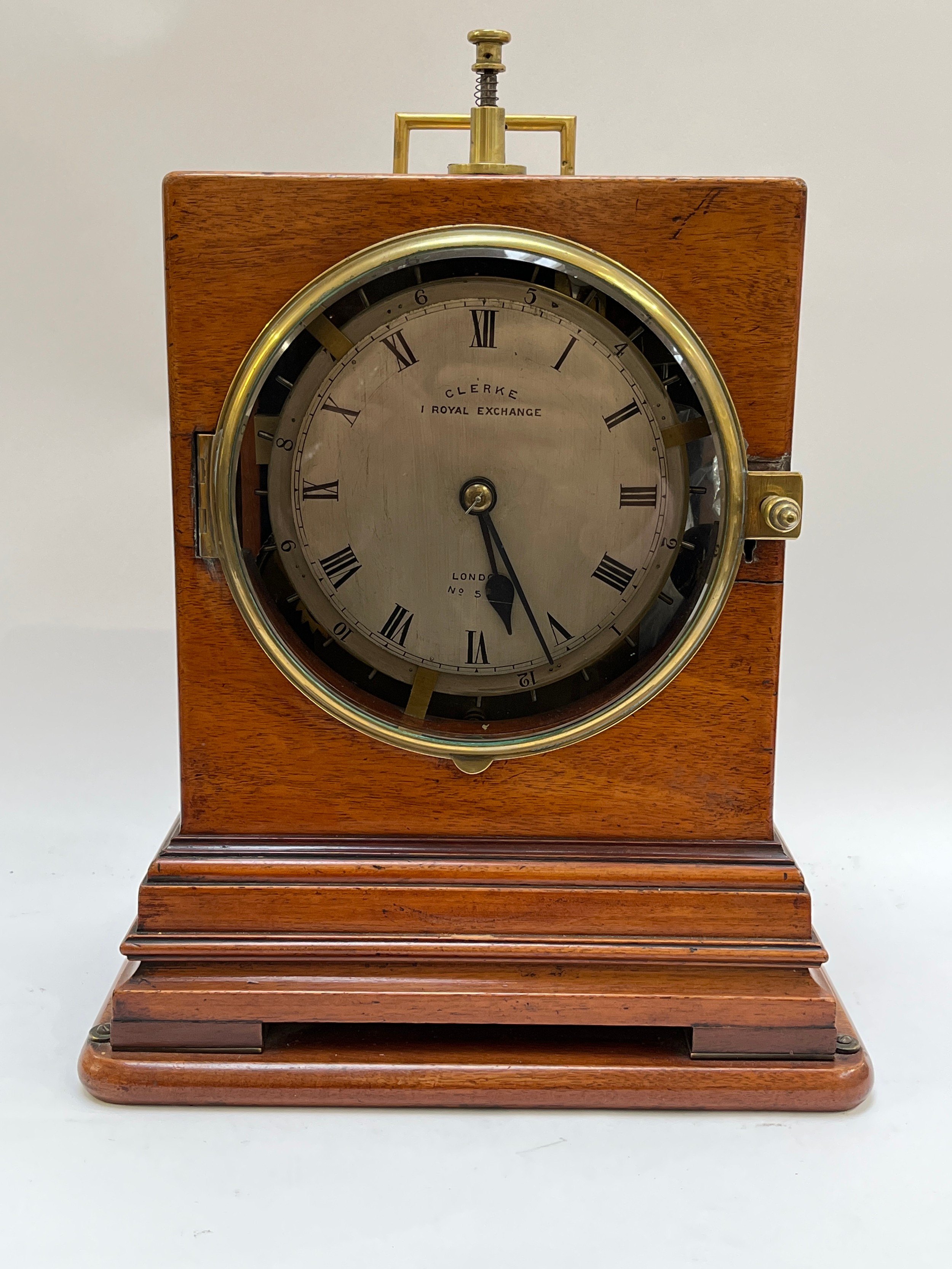 A Victorian watchman's shelf clock, dial marked Clerke, 1 Royal Exchange, London. Heavy brass