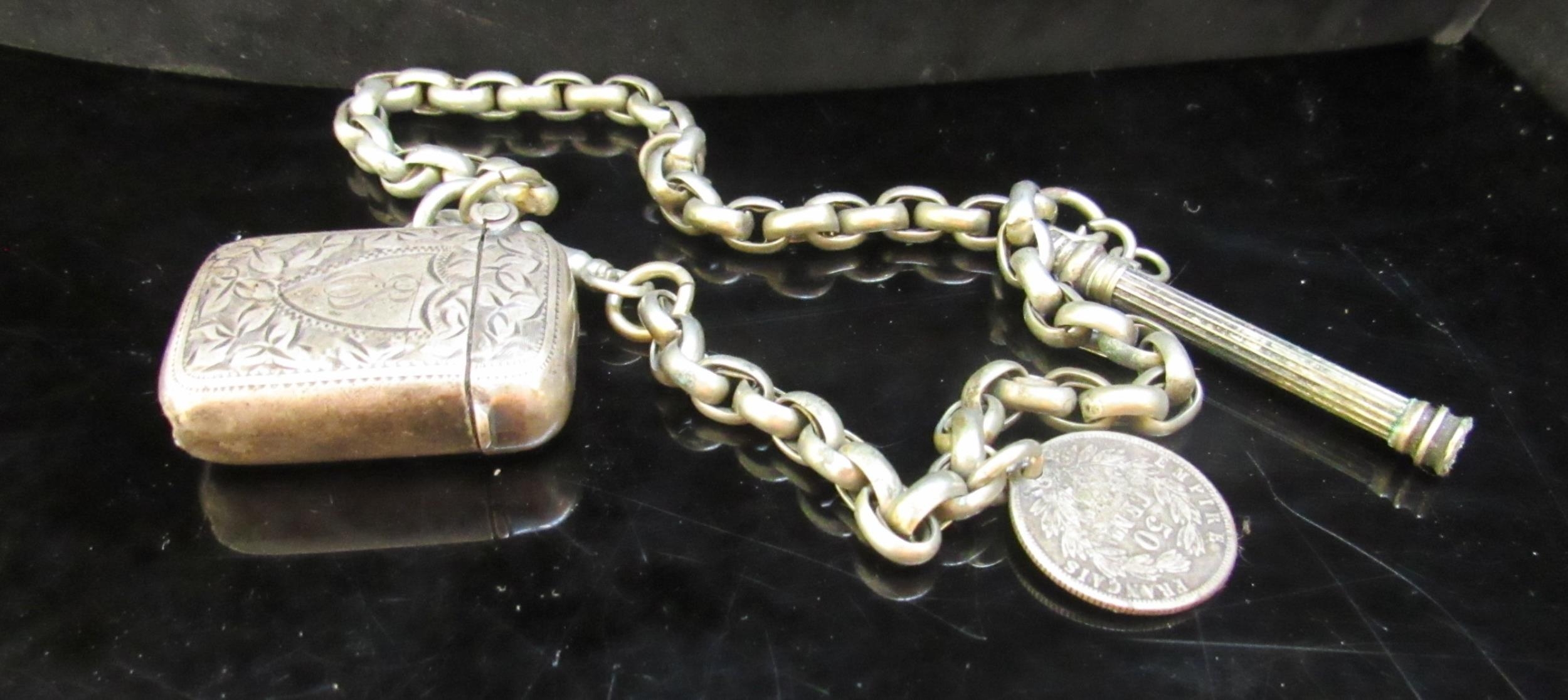 A small silver vesta hung on a watch chain with coin fob, 35g