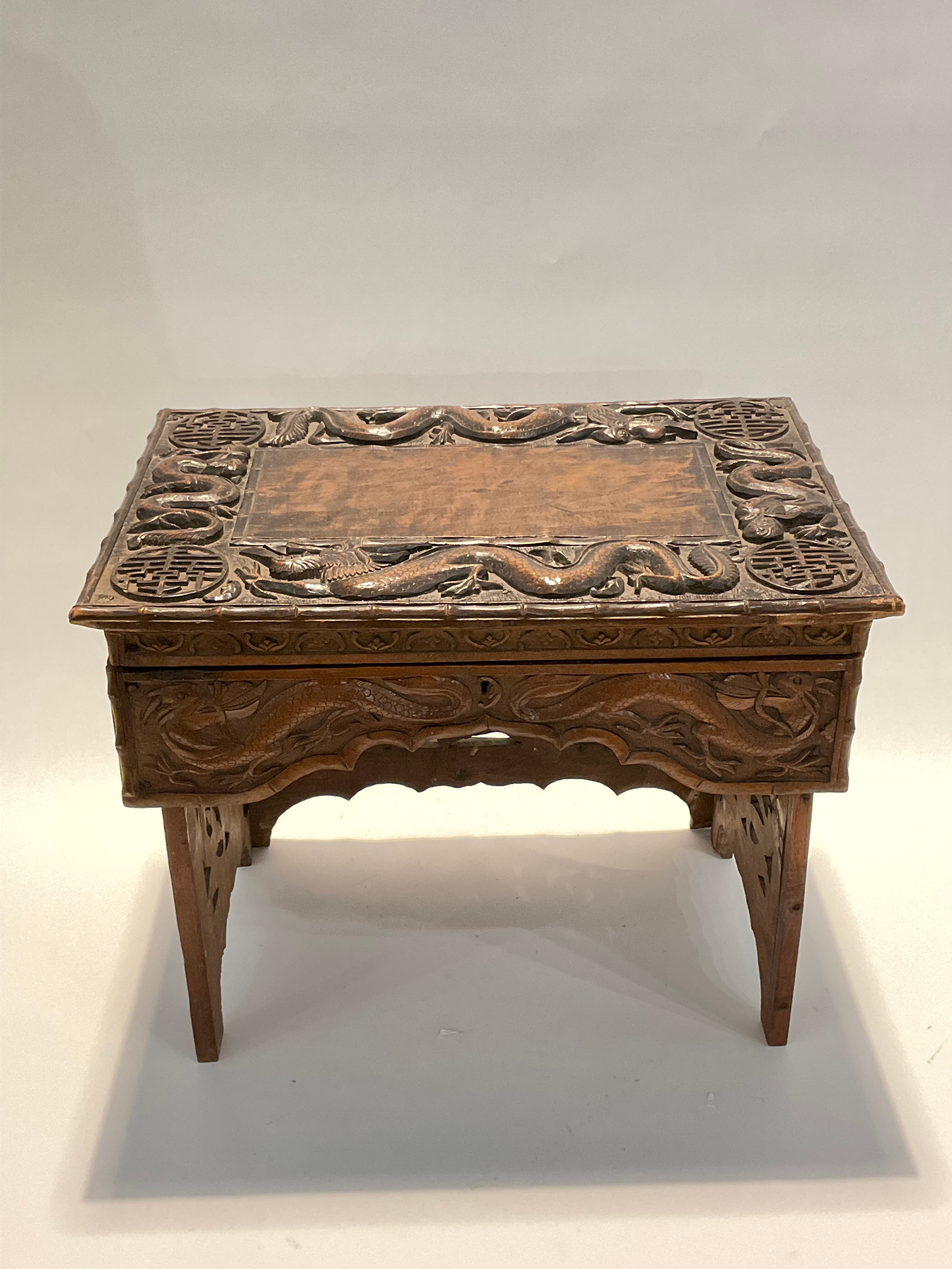A Korean hardwood tabletop chest, the lift lid opening to reveal storage, over a shaped frieze, on