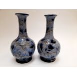 A pair of Doulton Lambeth blue bottle vases by Louisa J Davis, with incised sgraffito decoration.