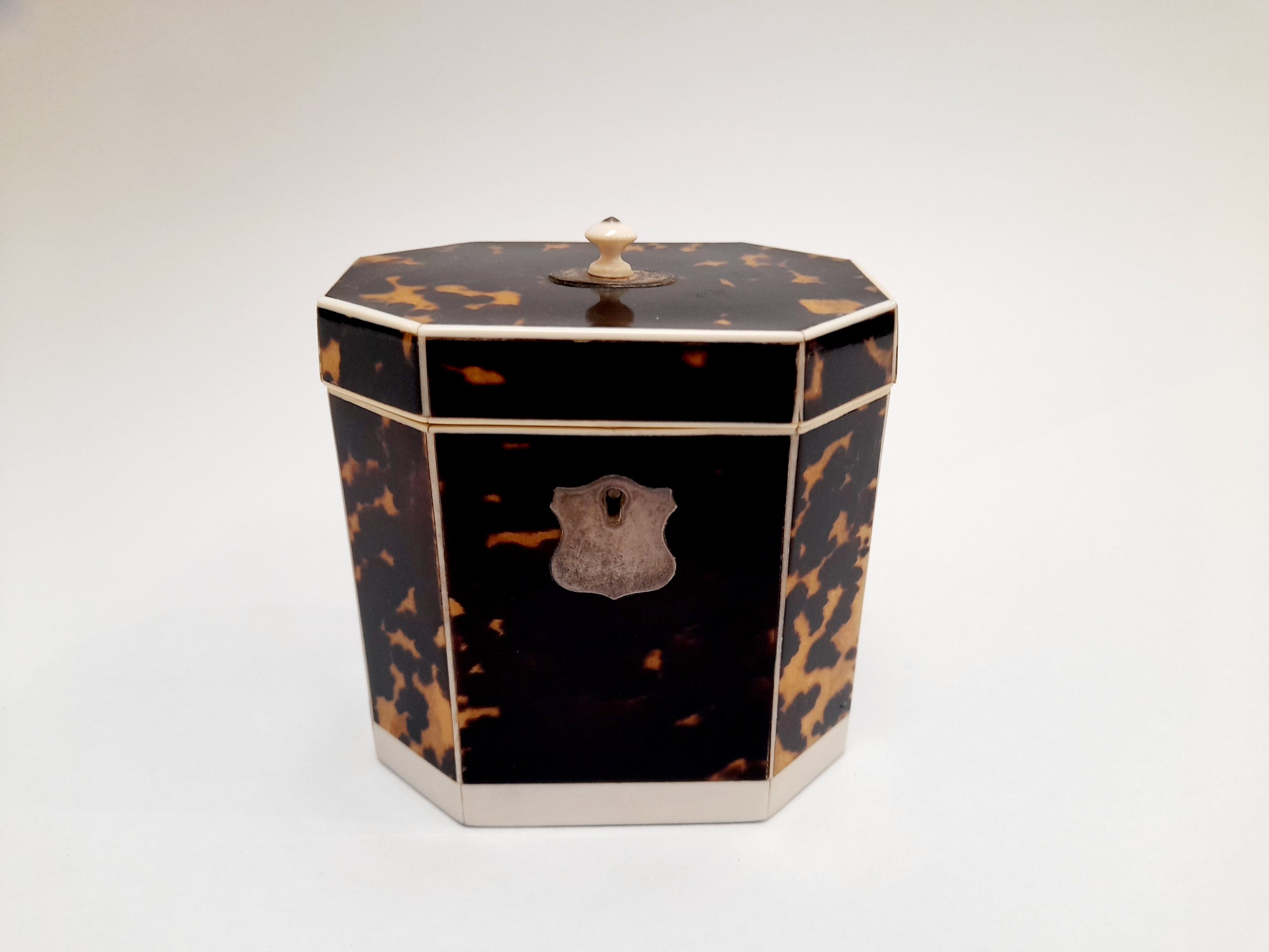 A Georgian tortoiseshell veneered tea caddy of canted rectangular form, with inner lid, ivory