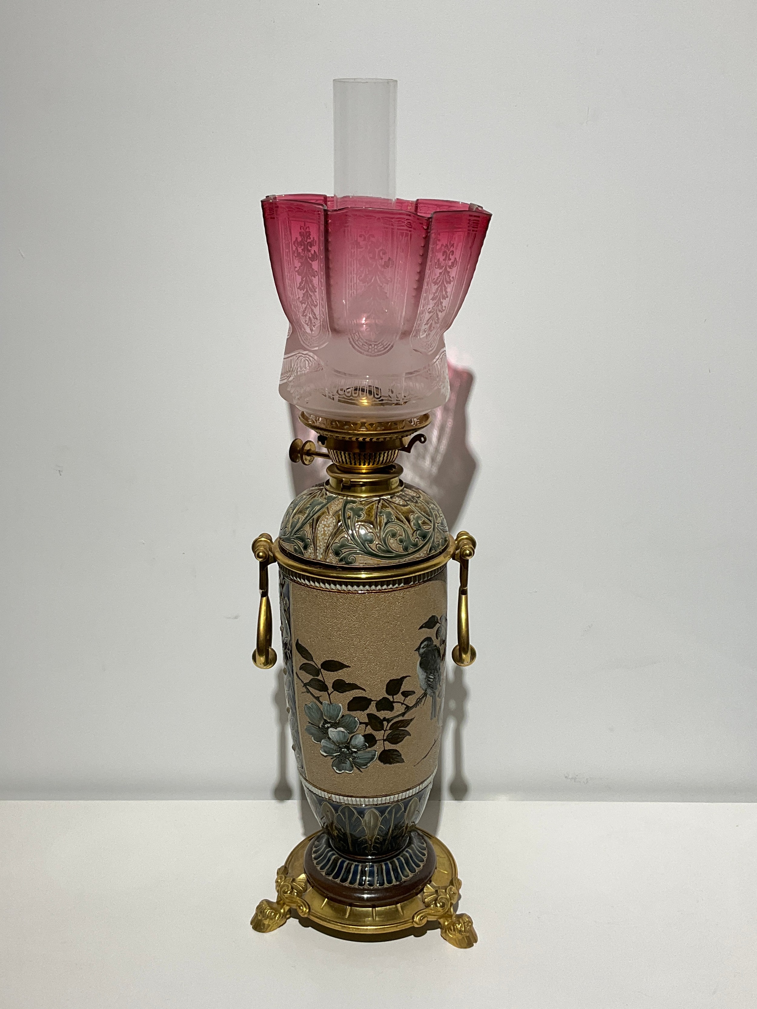 A Doulton Lambeth stoneware oil lamp with gilded mounts, by Hannah Barlow. Signed on internal