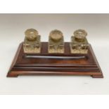 A 19th Century walnut deskstand with three substantial ink wells and pen tray, 37cm x 22cm