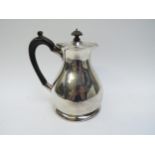 A Charles Edwards silver hot water jug with treen handle and knop, London 1919, major dent to