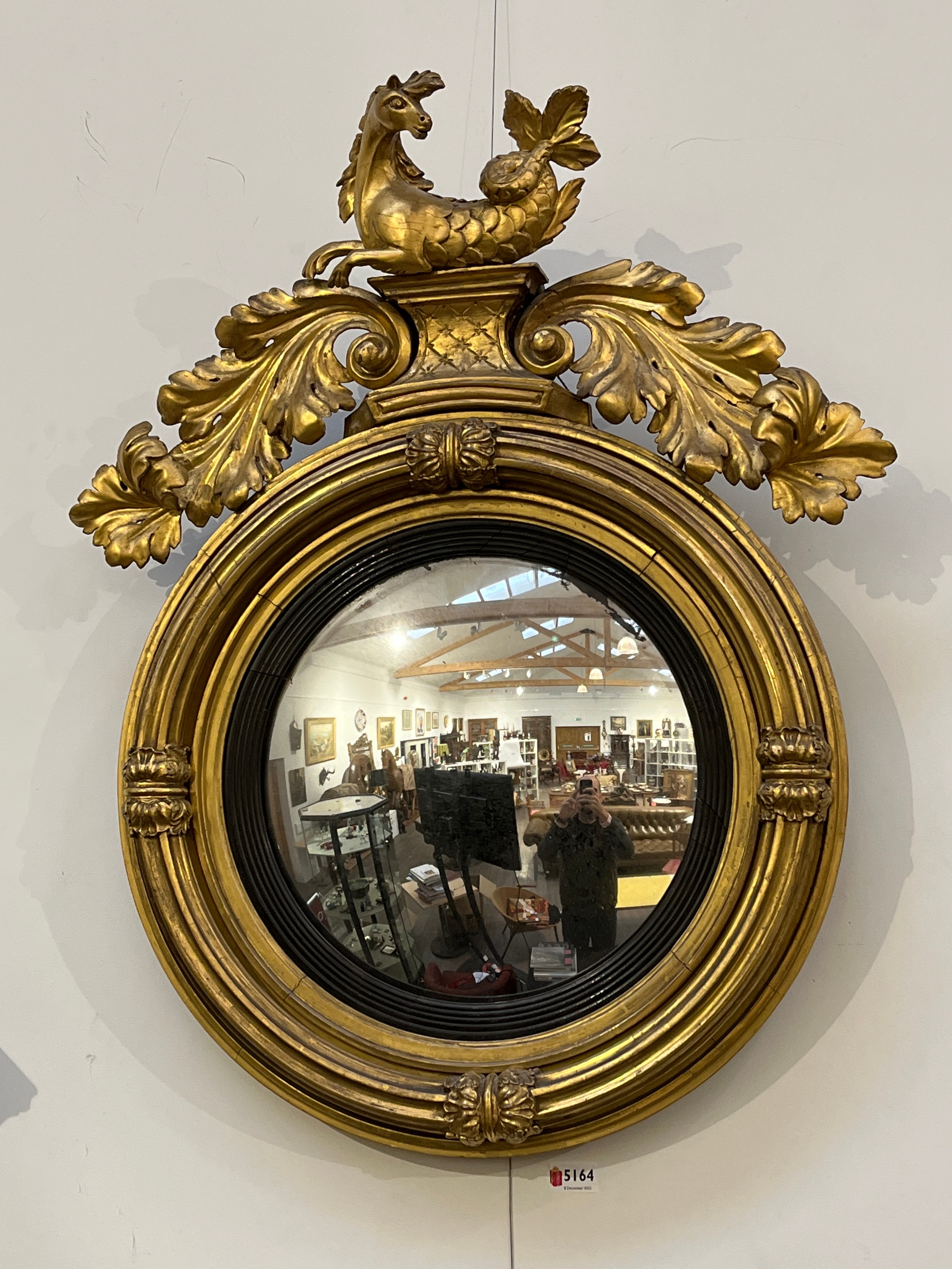 A late 18th/early 19th Century highly ornate gilt circular cover wall mirror with seahorse and