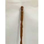 A European carved wood walking cane the carved handle as a man in a hat with a crocodile and snake