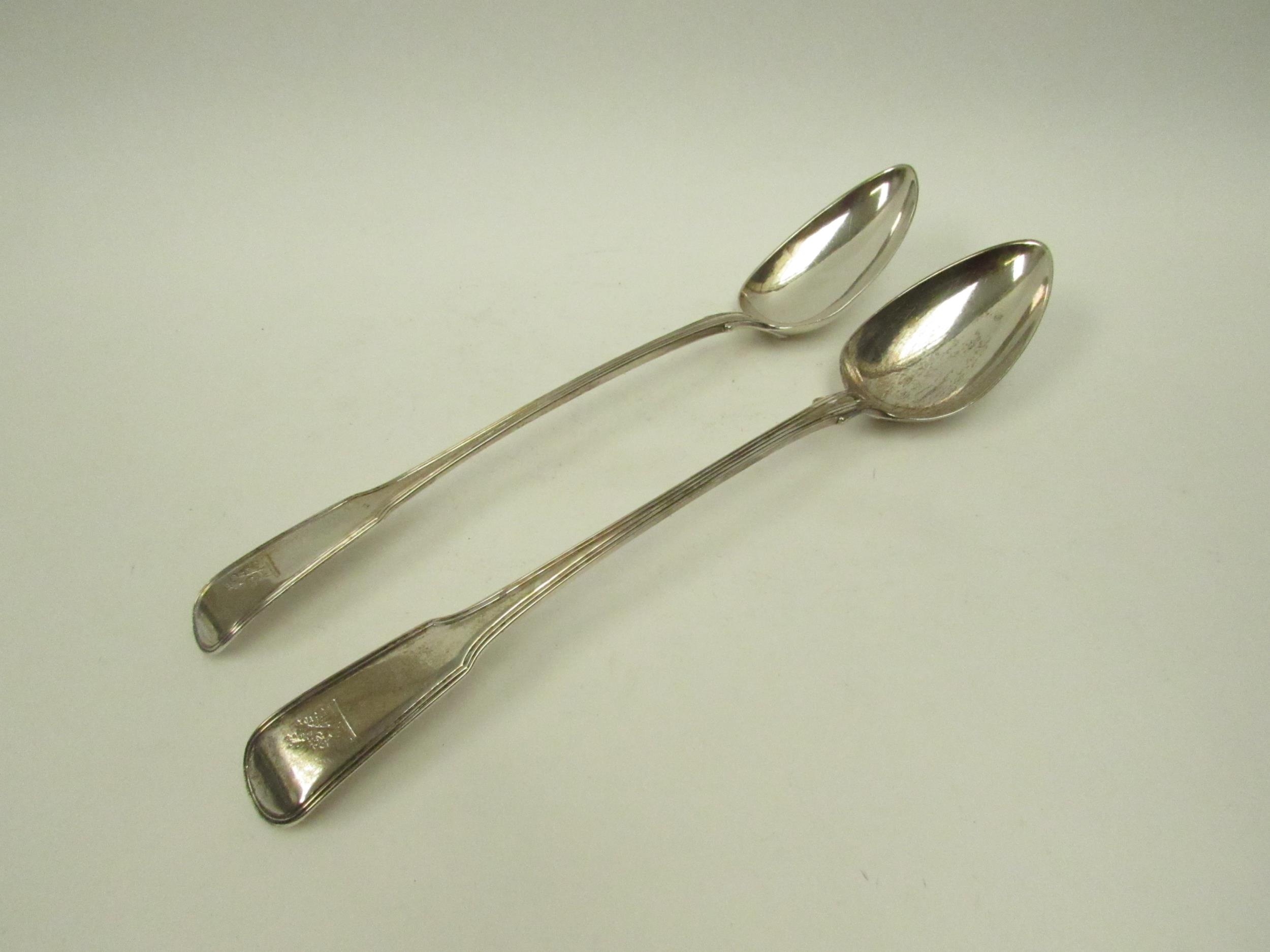 A pair of William Sumner I silver basting / stuffing spoons, family crest to terminal, London