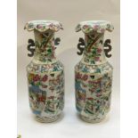 A pair of late 19th / early 20th Century Oriental porcelain vases in the Famille Rose design, panels