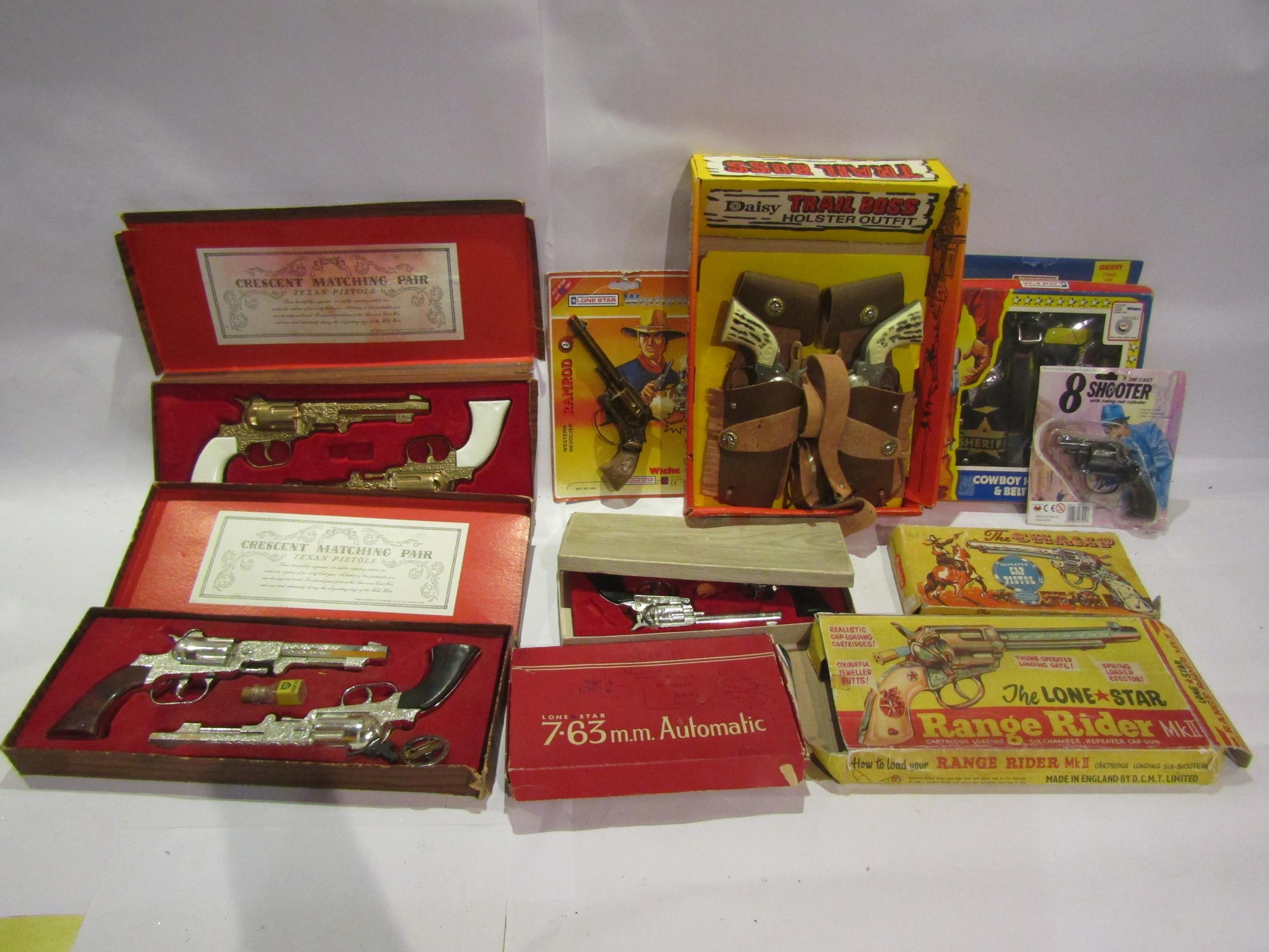 A collection of mostly boxed/carded toy guns, cap guns and pistols