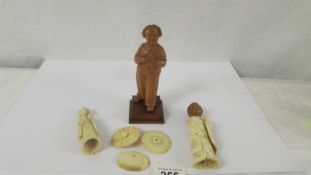 A carved wood figure and two antique a/f ivory figures.