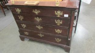 A mahogany period chest of drawers with brass handles and on bracket feet.