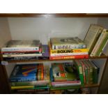 Two shelves of books including boxing related.