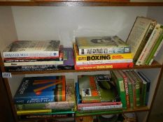 Two shelves of books including boxing related.