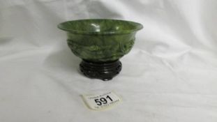 A small carved jade bowl on stand. 12.5cm diameter.