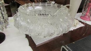A large glass punch bowl with 18 cups.