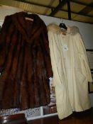 A vintage fur coat and a vintage cream hooded "cat" excavator coat.