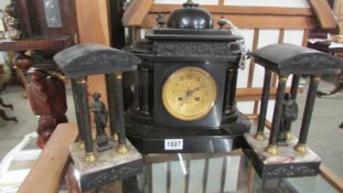 A Victorian black marble clock with two Grecian style side pieces. Collect only.