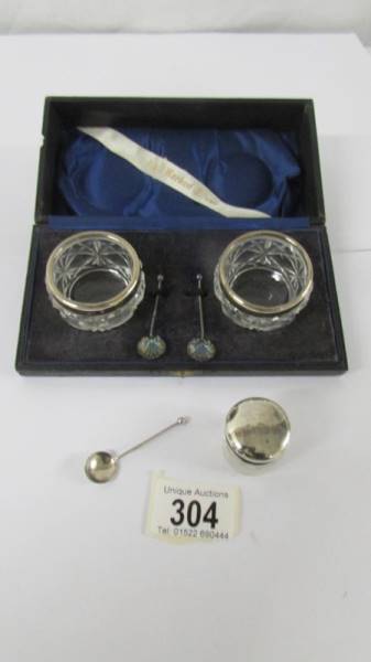 A cased pair of silver rimmed salts with spoons, a silver lidded pill box and a silver mustard