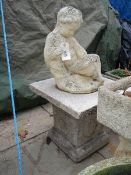 A cherub statue on square plinth and slab. 83 cm tall x 45 cm square maximum. Collect only.
