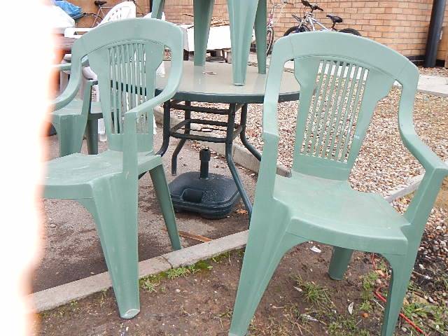 4 green plastic garden chairs, a parasol base and a table. Collect only. - Image 2 of 2